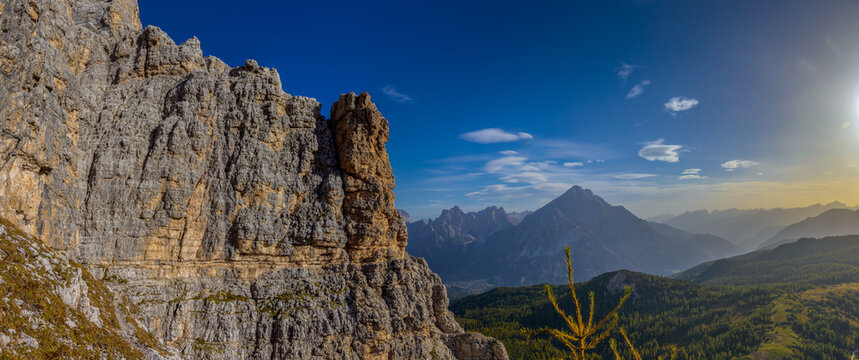 Panorama of the Dolomites mountains on a sunny day, blue sky with soe clouds. Beautiful mountians of Alpi Dolomiti in Italy, South Tirol alpine range in autumn