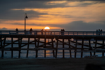 A beautiful golden beach sunset on a summer evening with people enjoying the scenery