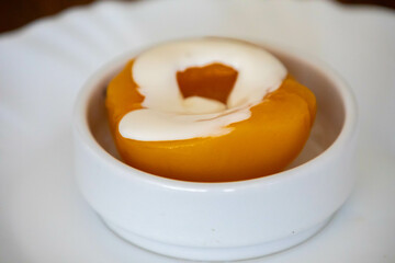 Traditional dessert of peaches in syrup with cream