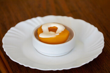 Traditional dessert of peaches in syrup with cream