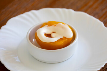 Traditional dessert of peaches in syrup with cream
