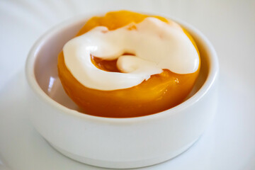 Traditional dessert of peaches in syrup with cream