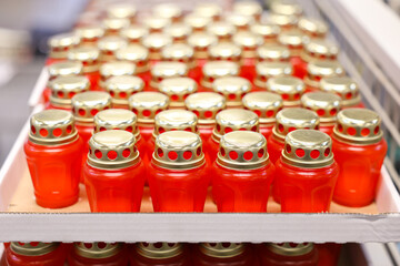 A row of red votive candles with gold tops