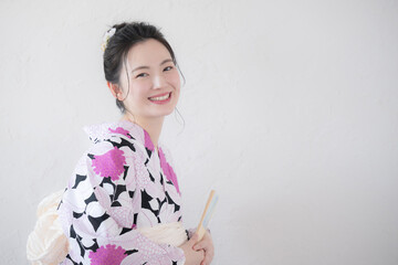 浴衣を着て扇子を持つ女性　上半身のカメラ目線