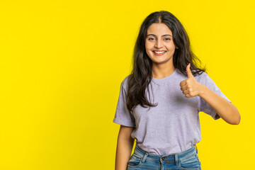 Like. Indian woman raises thumbs up agrees with something, gives positive reply recommends advertisement likes good idea feedback celebrating success victory. Girl isolated on studio yellow background