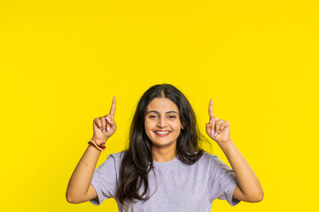 Indian woman showing thumbs up pointing overhead, above head empty place, advertising area for...