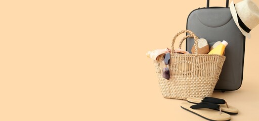 Suitcase with beach accessories on beige background with space for text