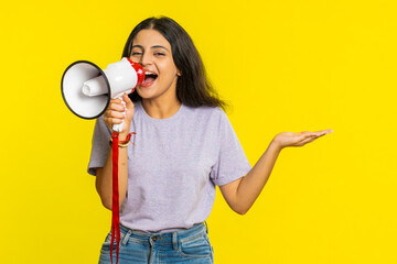 Indian young woman talking with megaphone, proclaiming news, loudly announcing advertisement...