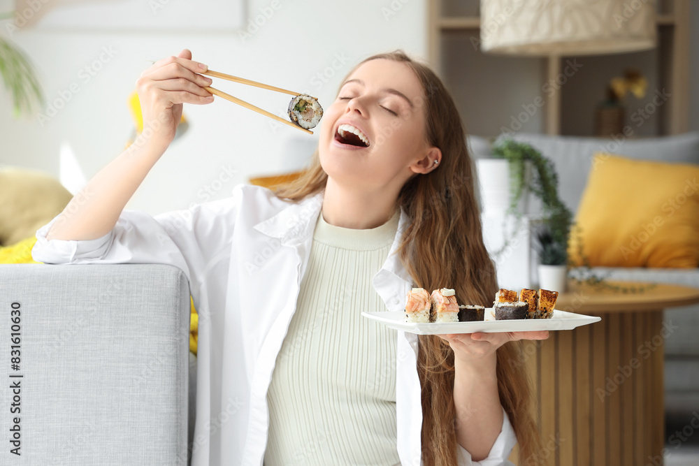 Canvas Prints Happy young woman eating sushi in living room