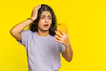Upset sad Indian woman use smartphone typing browsing, play game, loses, surprised by sudden...