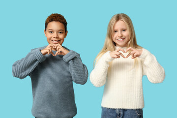 Cute little children showing heart gesture on blue background. Valentine's day celebration