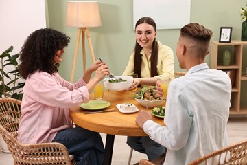 Friends having vegetarian meal at table in cafe