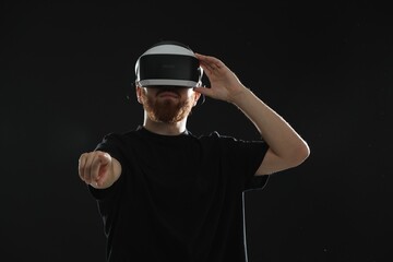Man using virtual reality headset on black background