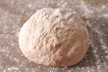 Fresh sourdough and flour on wooden table, closeup