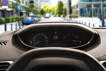 Dashboard with speedometer behind steering wheel inside car