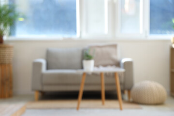 Blurred view of living room with sofa, table and window