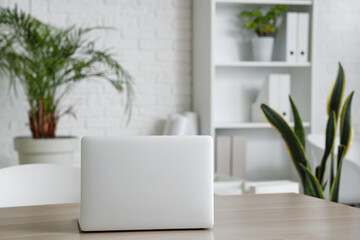 Modern laptop on desk in office, closeup