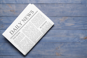Daily newspaper on blue wooden background