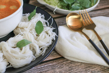 Kanom-jeen, Thai white noodle on wooden table eat with spicy curry sauce. Traditional thai food. 
