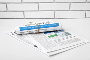 Different newspapers on white table