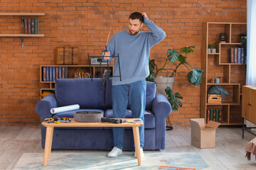 Troubled young man assembling pouf at home
