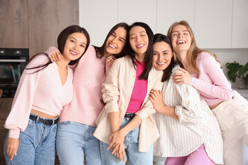 Young women hugging at Hen Party in kitchen