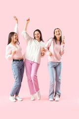 Fototapeta premium Happy young women with champagne on pink background. Hen Party