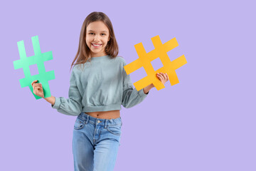 Cute teenage girl with hashtags on lilac background