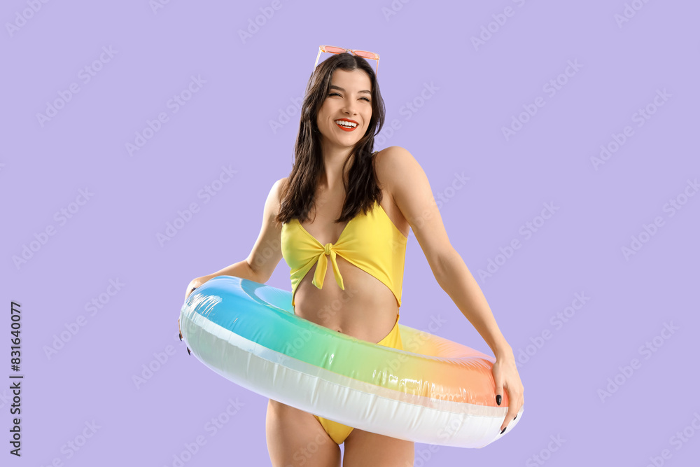 Poster beautiful young woman in beachwear with swim ring on lilac background