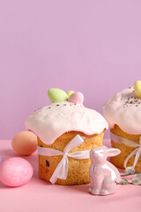 Composition with delicious Easter cakes, porcelain bunny and painted eggs on color background. Closeup