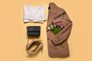 Stylish beige jacket with longsleeve,  high heels, bag, accessories and tulip flowers on beige...