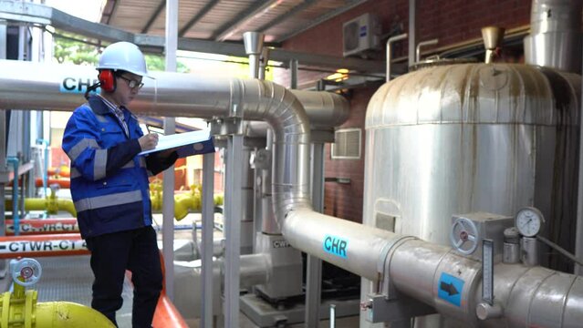 Engineer working in a room with steel pipes for cooling in a factory,constructing and checking development of a small business hall,Machine Maintenance Technician	
