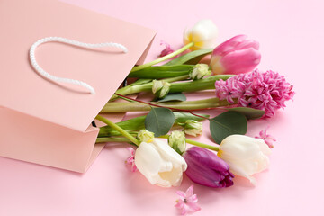 Paper shopping bag with flowers on pink background