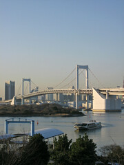 Obraz premium Rainbow Bridge and Tokyo cityscape view from Odaiba island with touring boat and pier