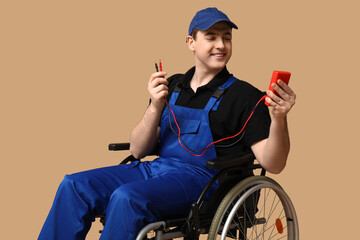 Male electrician in wheelchair with multimeter on beige background