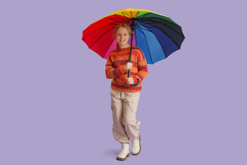 Adorable girl with umbrella on lilac background