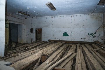 Old ruin room covered in dust with broken wooden logs in desolated abandoned building