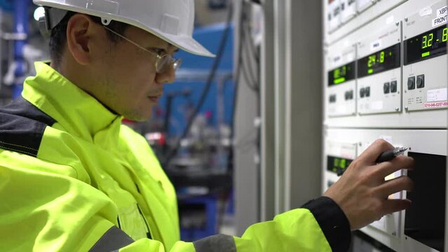 Electrical engineer inspects high-voltage electrical cabinet,Technician maintains the factory's electricity meter.