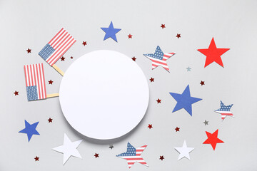 Obraz premium Composition with blank card, USA flags and stars on grey background. Independence Day celebration