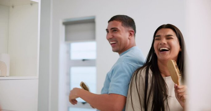 Home, mirror and couple with brushes, singing and happiness in marriage, silly and crazy in house. Goofy, man and woman in apartment, together and smile for romance, fun and dancing in bathroom