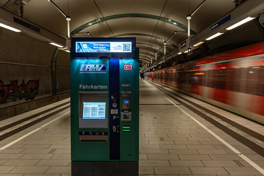 Ticket machine at the empty subway station with the train driving by