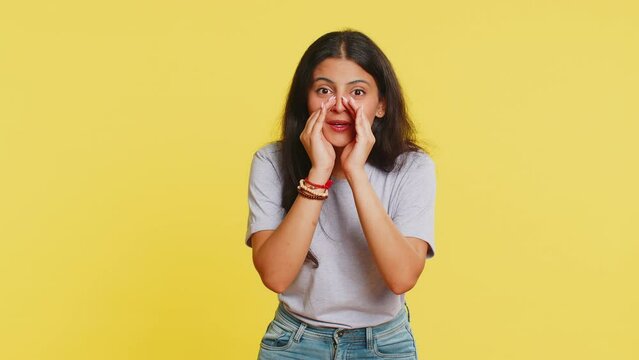 Keep my secrets, silence. Indian woman whisper news rumors holding hands near mouth share gossip quiet. Arabian girl telling interesting confidential story isolated on yellow background. Lifestyles