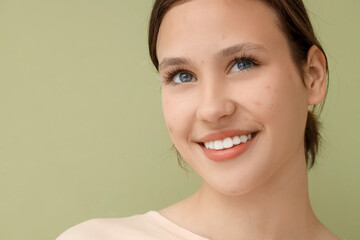 Beautiful young happy woman with acne problem on green background