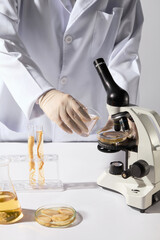 Frontal shot of a scientist holding a glass beaker containing yellow liquid, preparing to pour it...