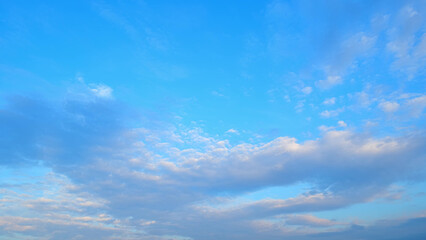 A bright blue sky with a mix of scattered clouds, varying from light and fluffy to more dense...