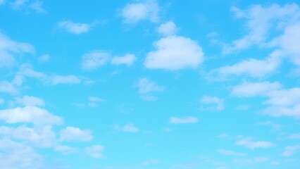 A clear blue sky filled with small, scattered white clouds. The clouds are thin and fluffy,...