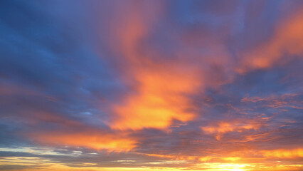 A vibrant sunrise, with the sky ablaze in shades of orange and pink, blending into deep blue. The...