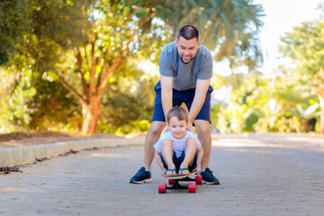 A Brazilian father happily pushes his young son on a skateboard down the neighborhood street. The image captures joyful moments between father and son, celebrating Father's Day