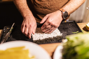 Rolling sushi with seaweed and rice