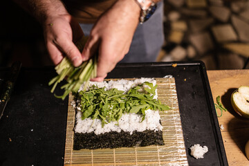 Preparing sushi roll with fresh vegetables